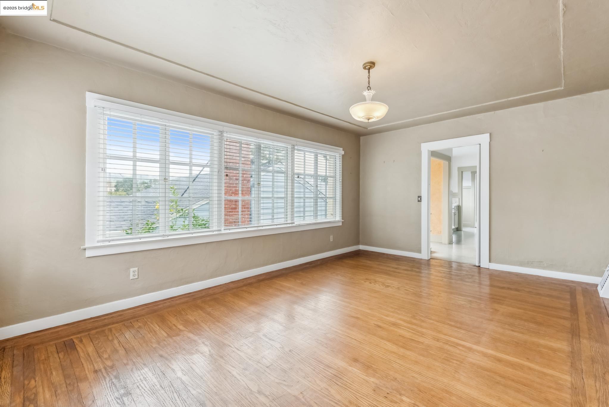 Undisclosed Address Oakland, CA 94610 - Photo 12 of 34 wooden floor in an empty room with a window