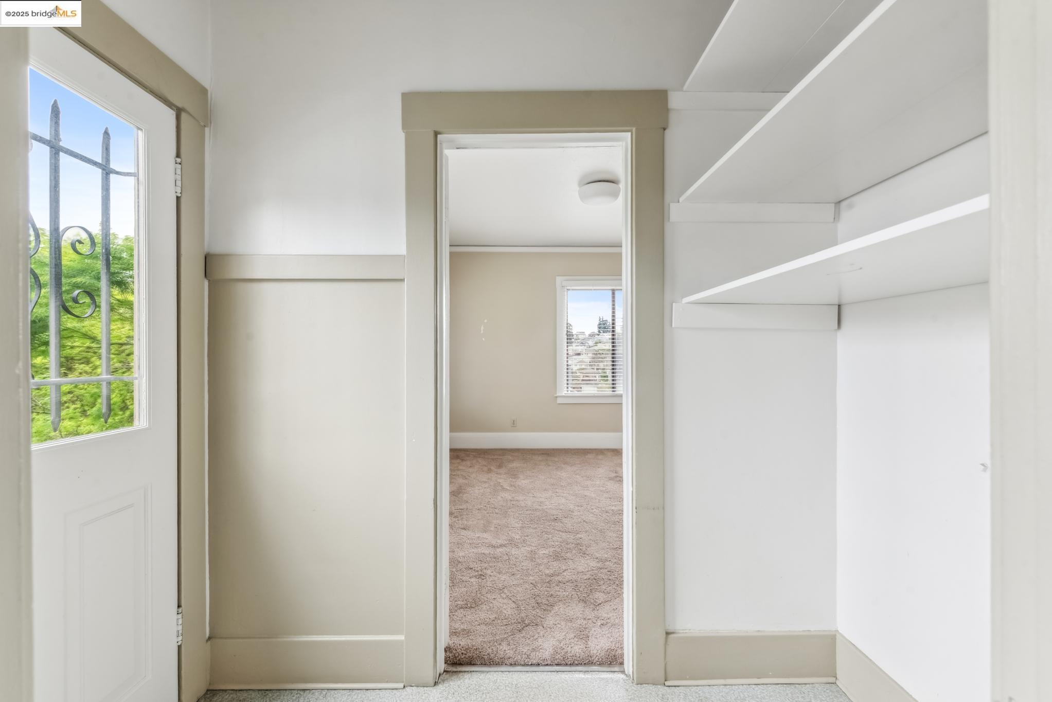 Undisclosed Address Oakland, CA 94610 - Photo 19 of 34 a view of hallway with a large window and potted plants