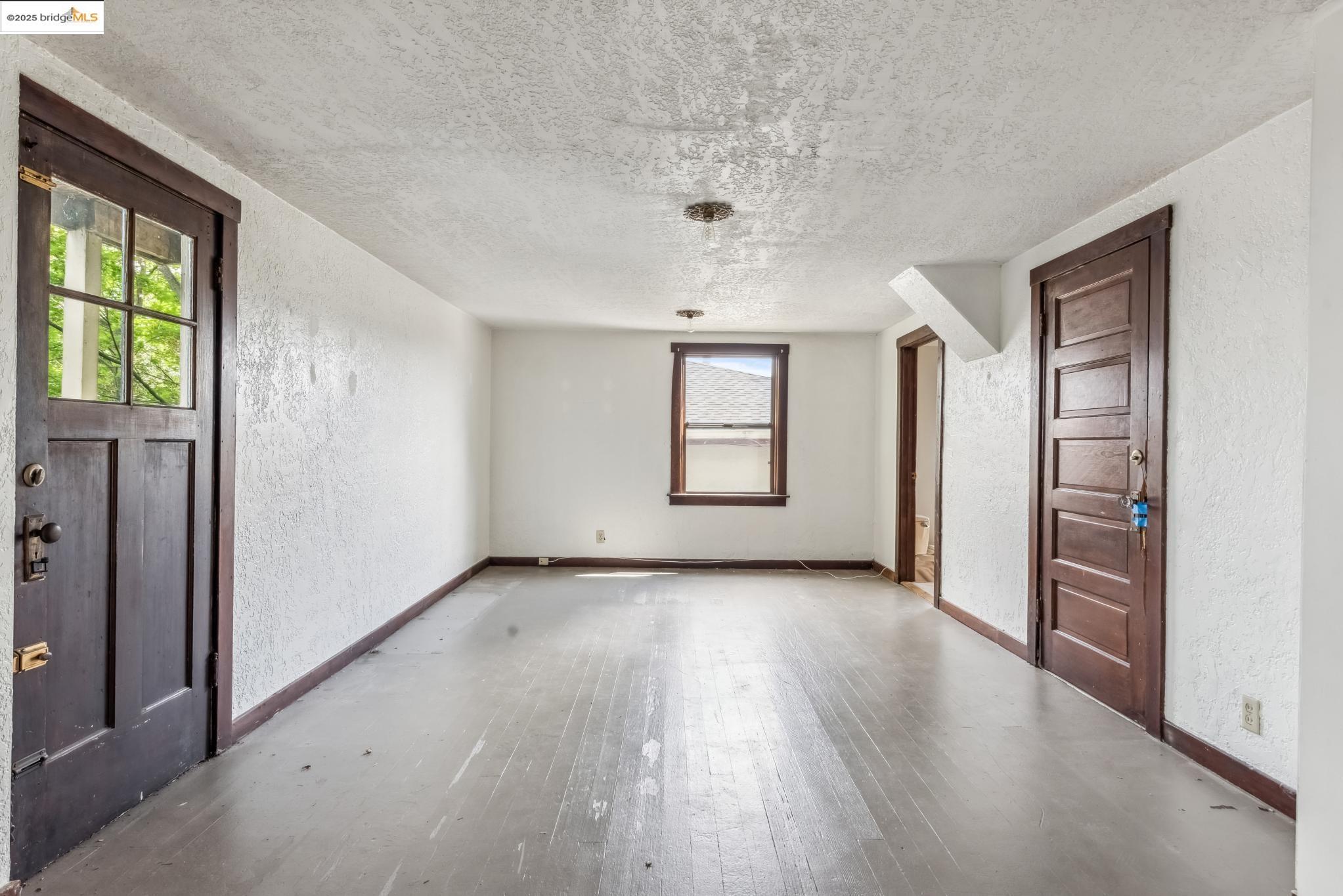 Undisclosed Address Oakland, CA 94610 - Photo 30 of 34 an empty room with wooden floor and windows