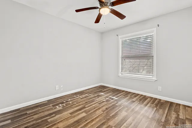 a view of a room with a window and a ceiling fan