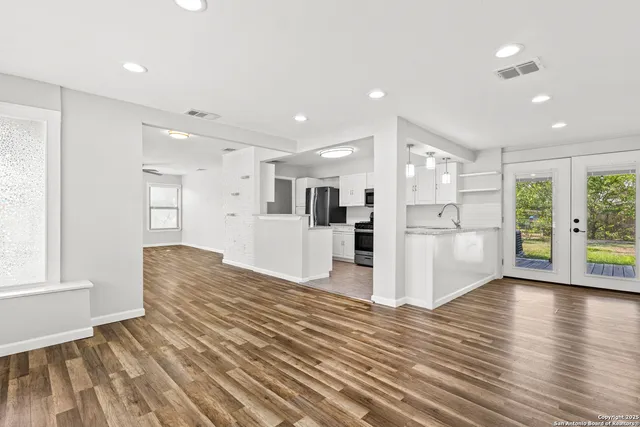 a view of a kitchen with wooden floor and windows