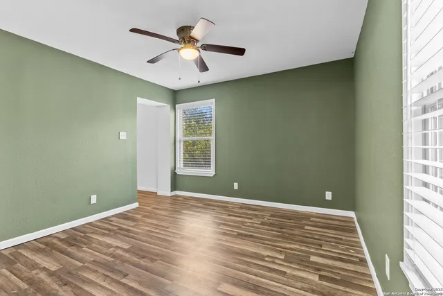 a view of a room with a ceiling fan and window
