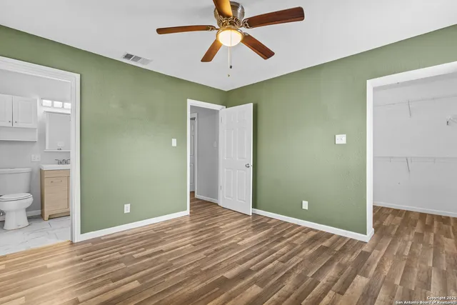 a view of a room with a ceiling fan and wooden floor