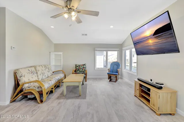 a living room with furniture flat screen tv and window