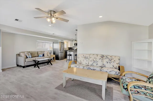 a living room with furniture and a dining table with kitchen view