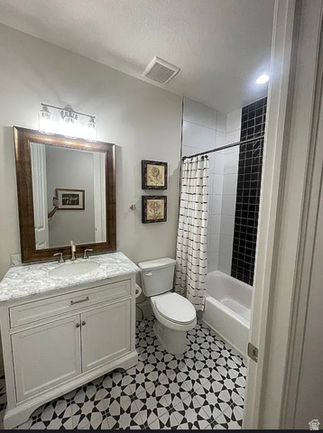 838 East Mountain Road North Ogden, UT 84414 - Photo 16 of 37 Bathroom featuring a patterned black and white floor, a white vanity with a light-colored countertop, and a shower/tub combination with black subway tile accents