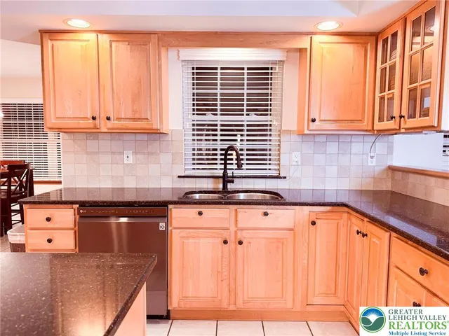 a kitchen with granite countertop a sink a stove and cabinets