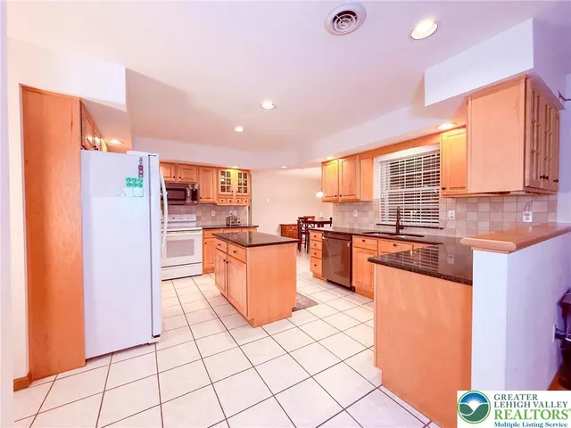 a kitchen with stainless steel appliances granite countertop a refrigerator and a stove top oven