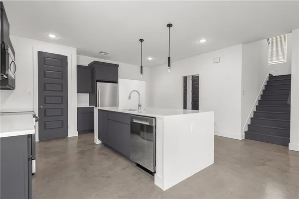 a kitchen with stainless steel appliances kitchen island a refrigerator and a sink