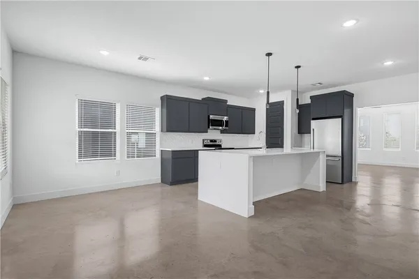 a large kitchen with kitchen island a sink stainless steel appliances and cabinets