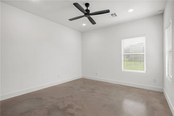 an empty room with a window and a fan