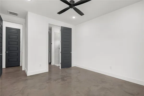 an empty room with closet and ceiling fan