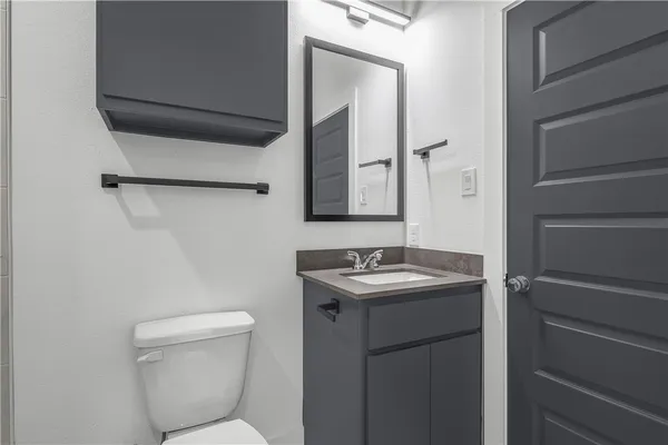 a bathroom with a toilet sink and mirror