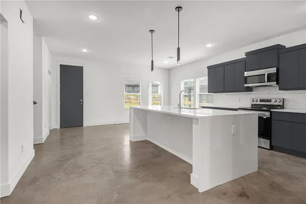 a kitchen with stainless steel appliances granite countertop a refrigerator and a stove top oven