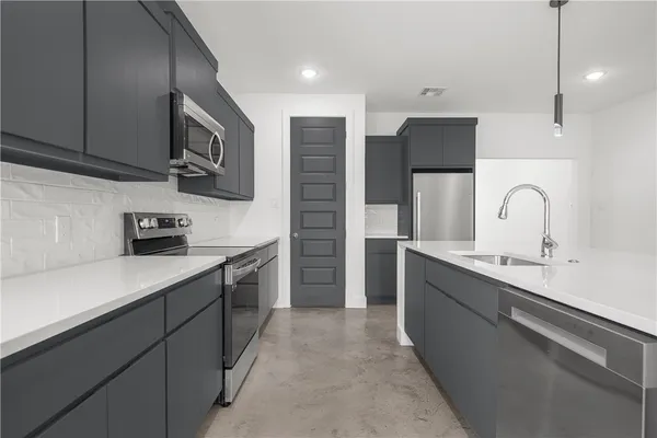 a kitchen with stainless steel appliances a sink cabinets and a refrigerator