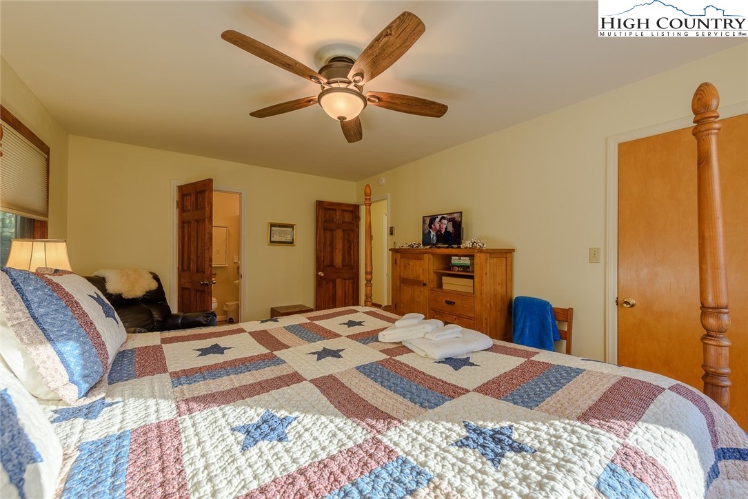 1776 Beech Mountain Parkway Beech Mountain, NC 28604 - Photo 18 of 34 a bedroom with a bed and a chandelier