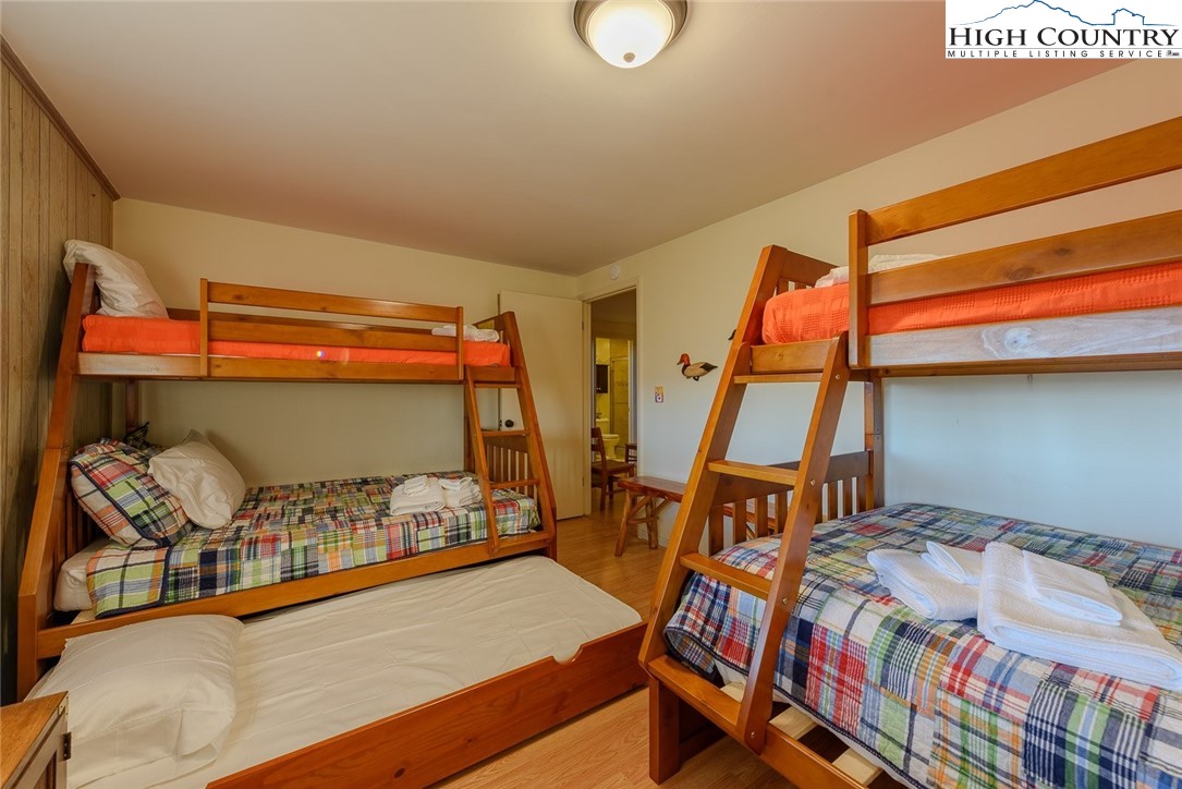 1776 Beech Mountain Parkway Beech Mountain, NC 28604 - Photo 21 of 34 a bedroom with a bed and wooden floor
