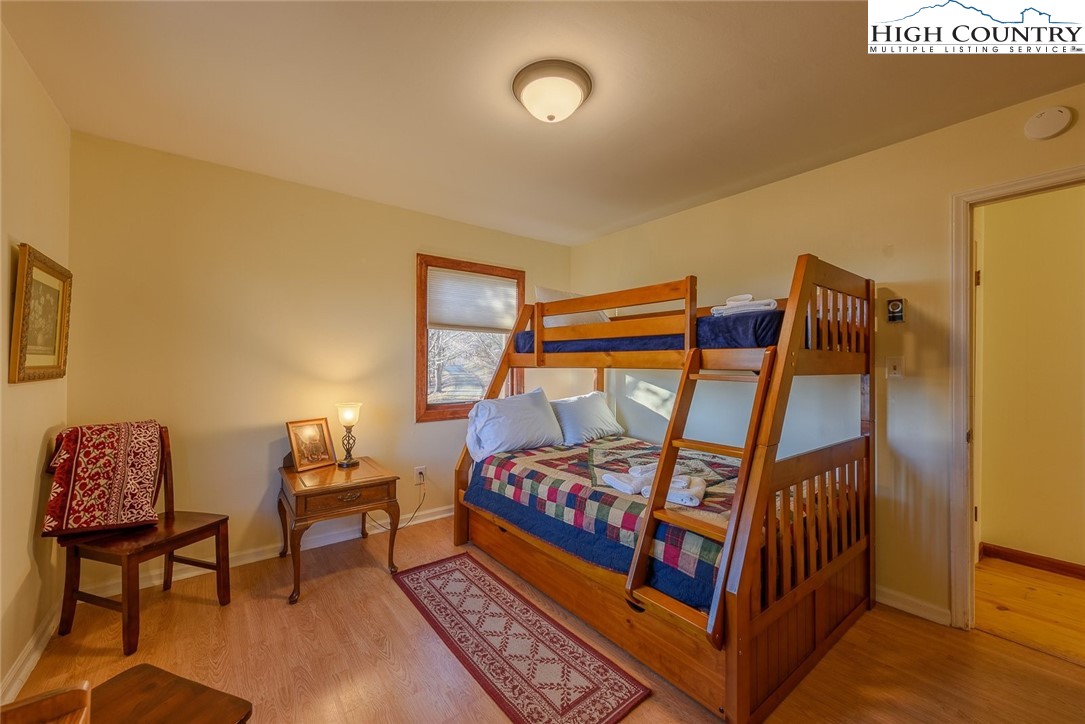 1776 Beech Mountain Parkway Beech Mountain, NC 28604 - Photo 22 of 34 a bedroom with furniture and a lamp