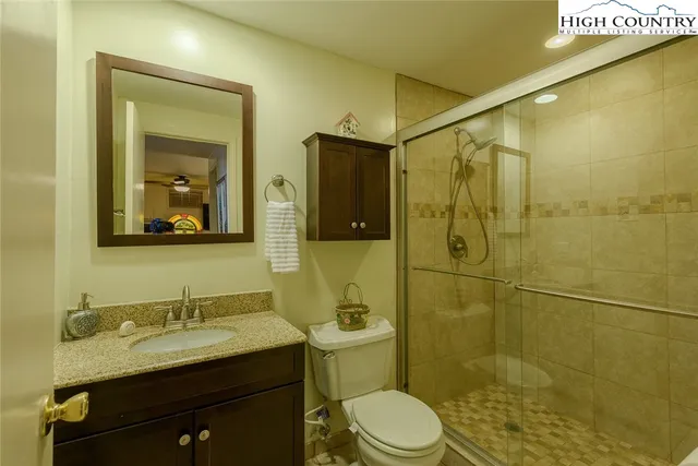 a bathroom with a granite countertop sink toilet and shower