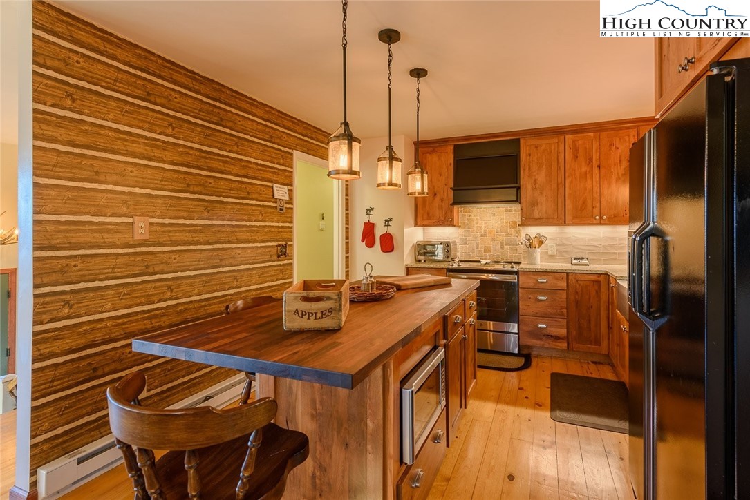1776 Beech Mountain Parkway Beech Mountain, NC 28604 - Photo 8 of 34 a kitchen with stainless steel appliances a stove a sink refrigerator and a microwave