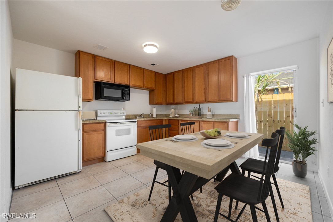 12955 First Street Fort Myers, FL 33905 - Photo 11 of 48 a kitchen with a dining table chairs and refrigerator