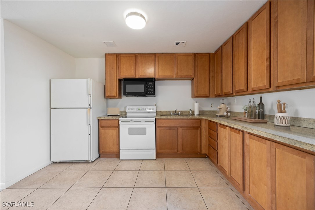 12955 First Street Fort Myers, FL 33905 - Photo 12 of 48 a kitchen with a sink a stove and refrigerator