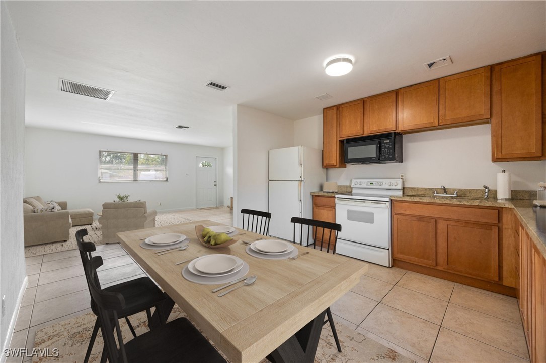 12955 First Street Fort Myers, FL 33905 - Photo 13 of 48 a open dining room with stainless steel appliances a table and chairs