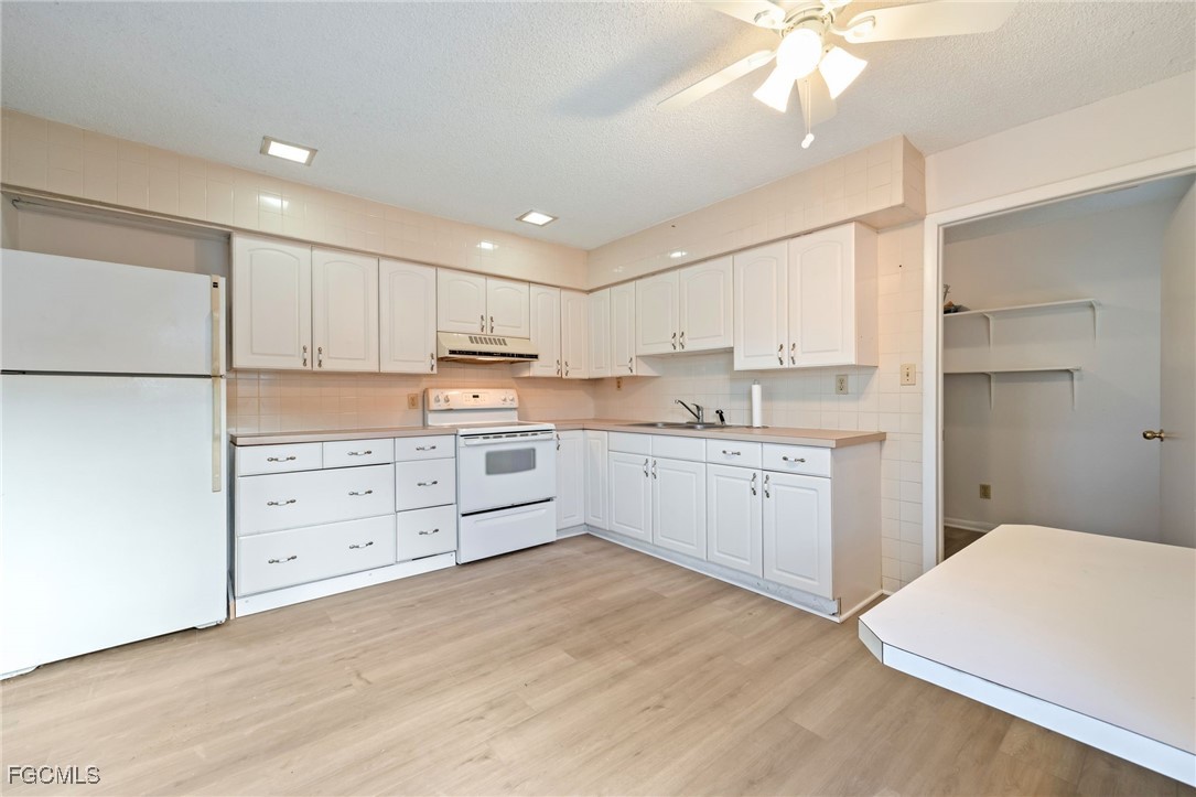 12955 First Street Fort Myers, FL 33905 - Photo 30 of 48 a kitchen with white cabinets and white appliances