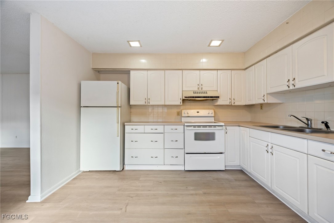 12955 First Street Fort Myers, FL 33905 - Photo 31 of 48 a kitchen with white cabinets and white appliances