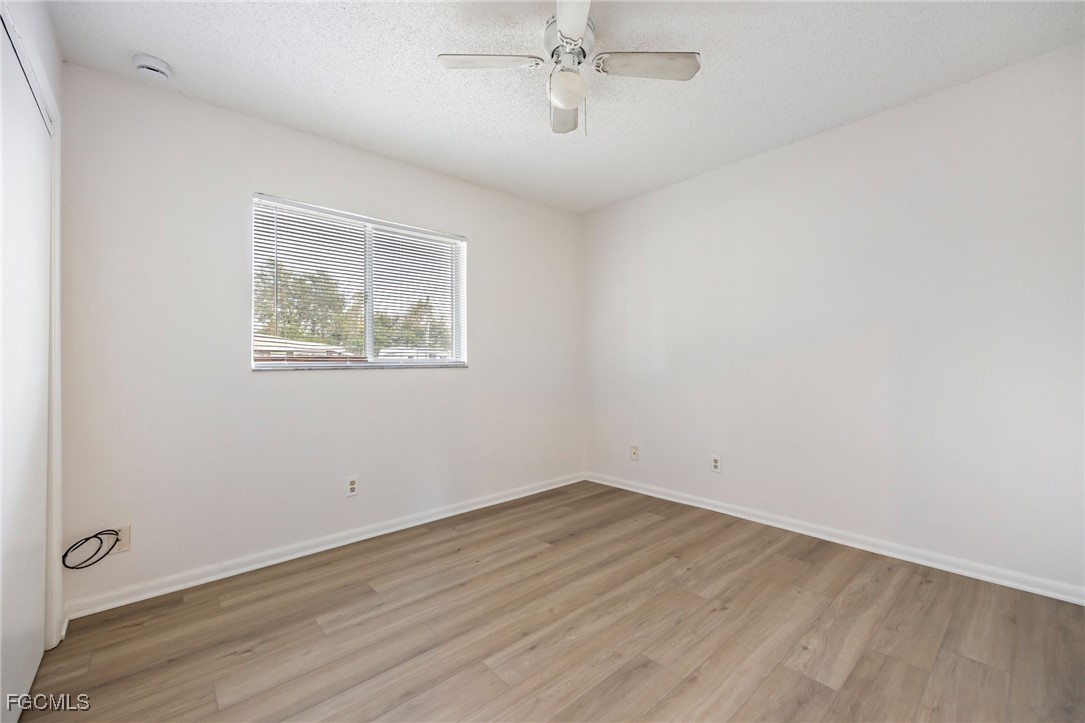 12955 First Street Fort Myers, FL 33905 - Photo 35 of 48 an empty room with wooden floor and ceiling fan