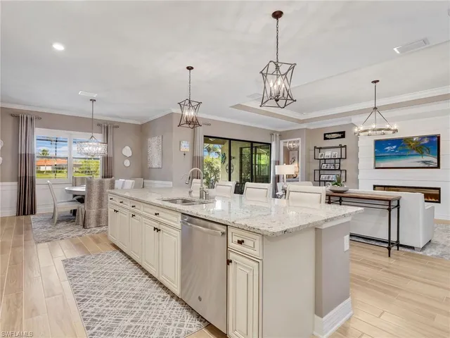 a kitchen with stainless steel appliances granite countertop a sink dishwasher and white cabinets with wooden floor