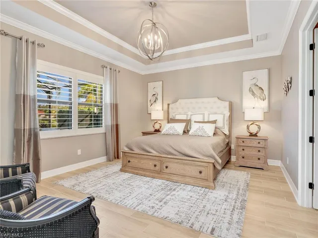 a bedroom with a large bed and a chandelier