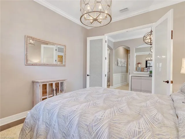 a bedroom with a large bed and a chandelier