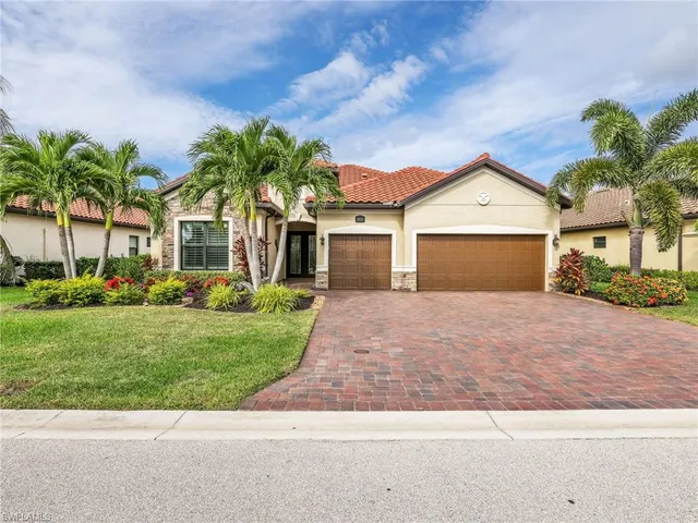 front view of a house with a yard and palm trees