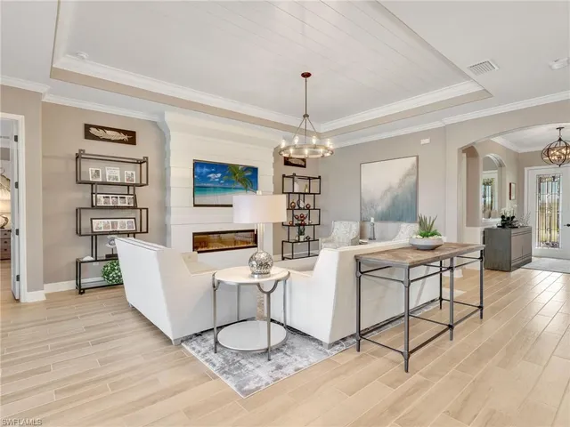 a living room with furniture a dining table and a chandelier