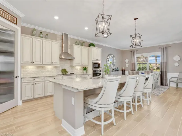 a kitchen with stainless steel appliances kitchen island granite countertop a wooden floor and white cabinets