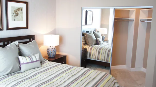 a bedroom with a bed and a potted plant next to a window