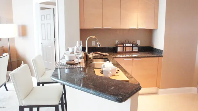 a kitchen with stainless steel appliances granite countertop a sink and a stove