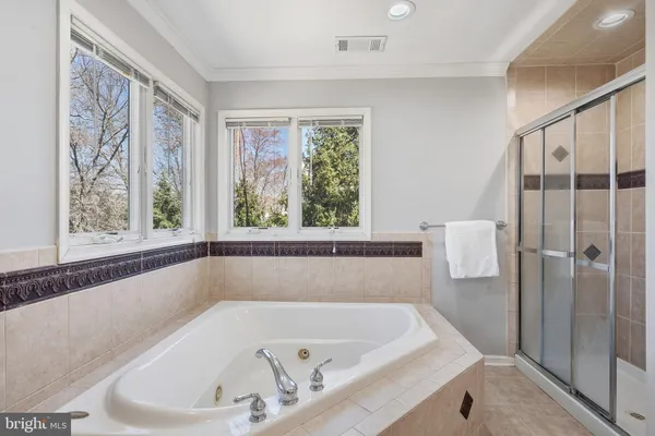 a white bath tub sitting in a bathroom next to a window