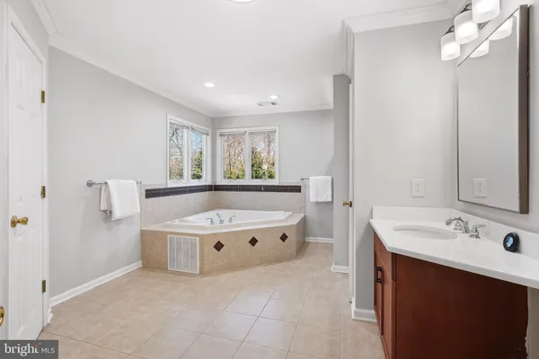 a spacious bathroom with a bathtub a sink and a mirror