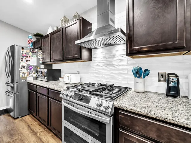 a large kitchen with stainless steel appliances kitchen island granite countertop a large stove top oven and cabinets