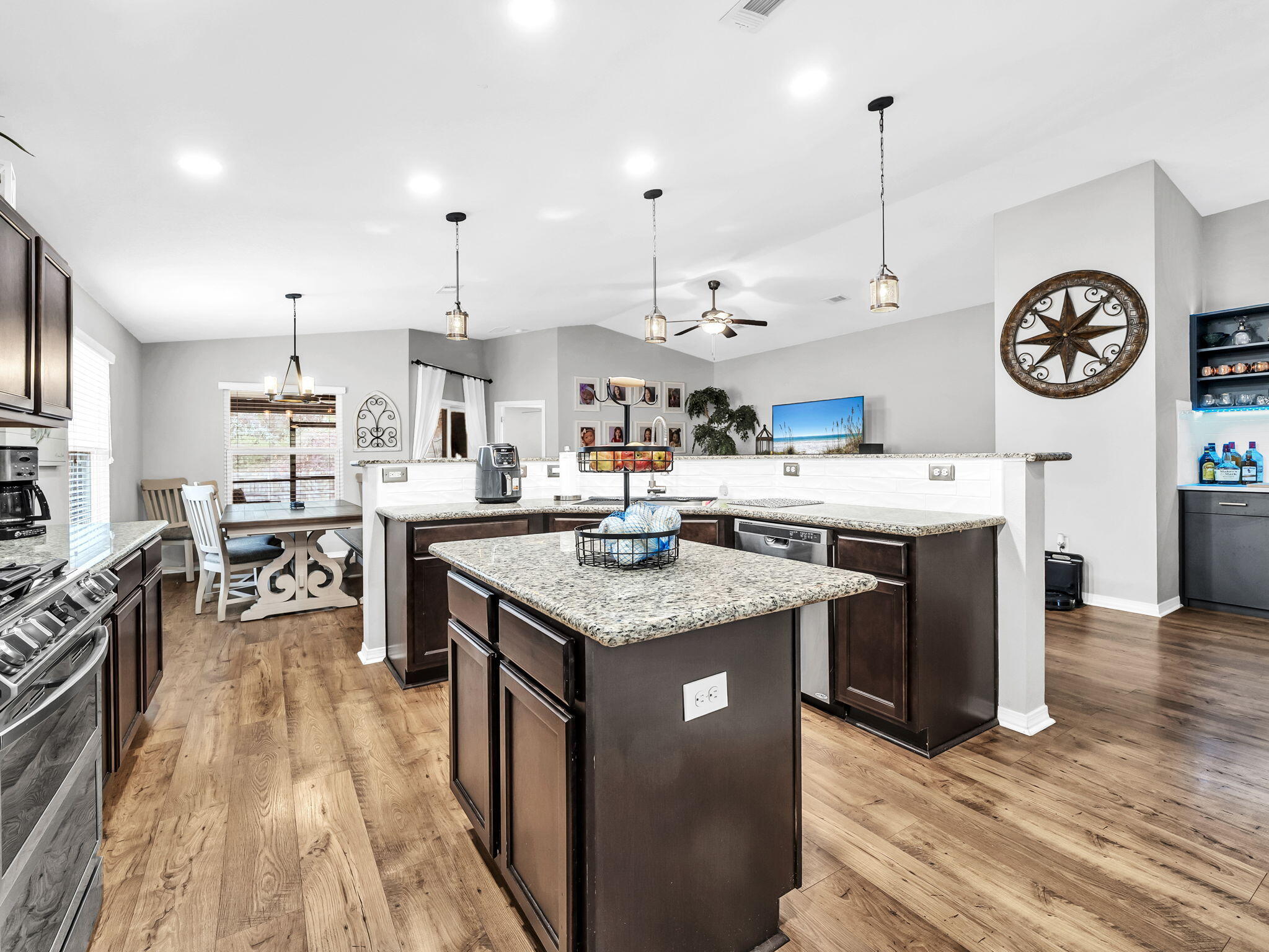 9119 Timber Lane Navarre, FL 32566 - Photo 18 of 53 a kitchen with stainless steel appliances granite countertop a stove oven a dining table and chairs with wooden floor