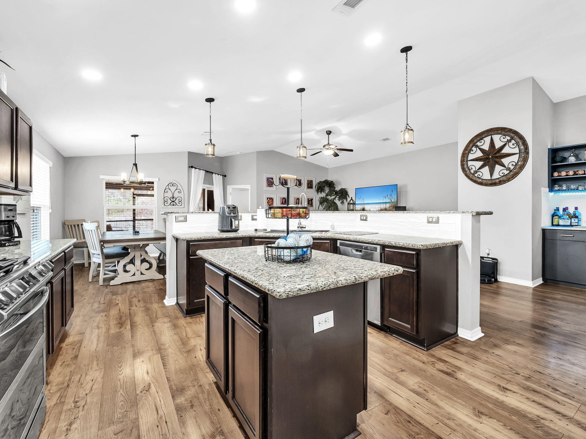 9119 Timber Lane Navarre, FL 32566 - Photo 19 of 53 a kitchen with stainless steel appliances granite countertop a stove oven a dining table and chairs with wooden floor