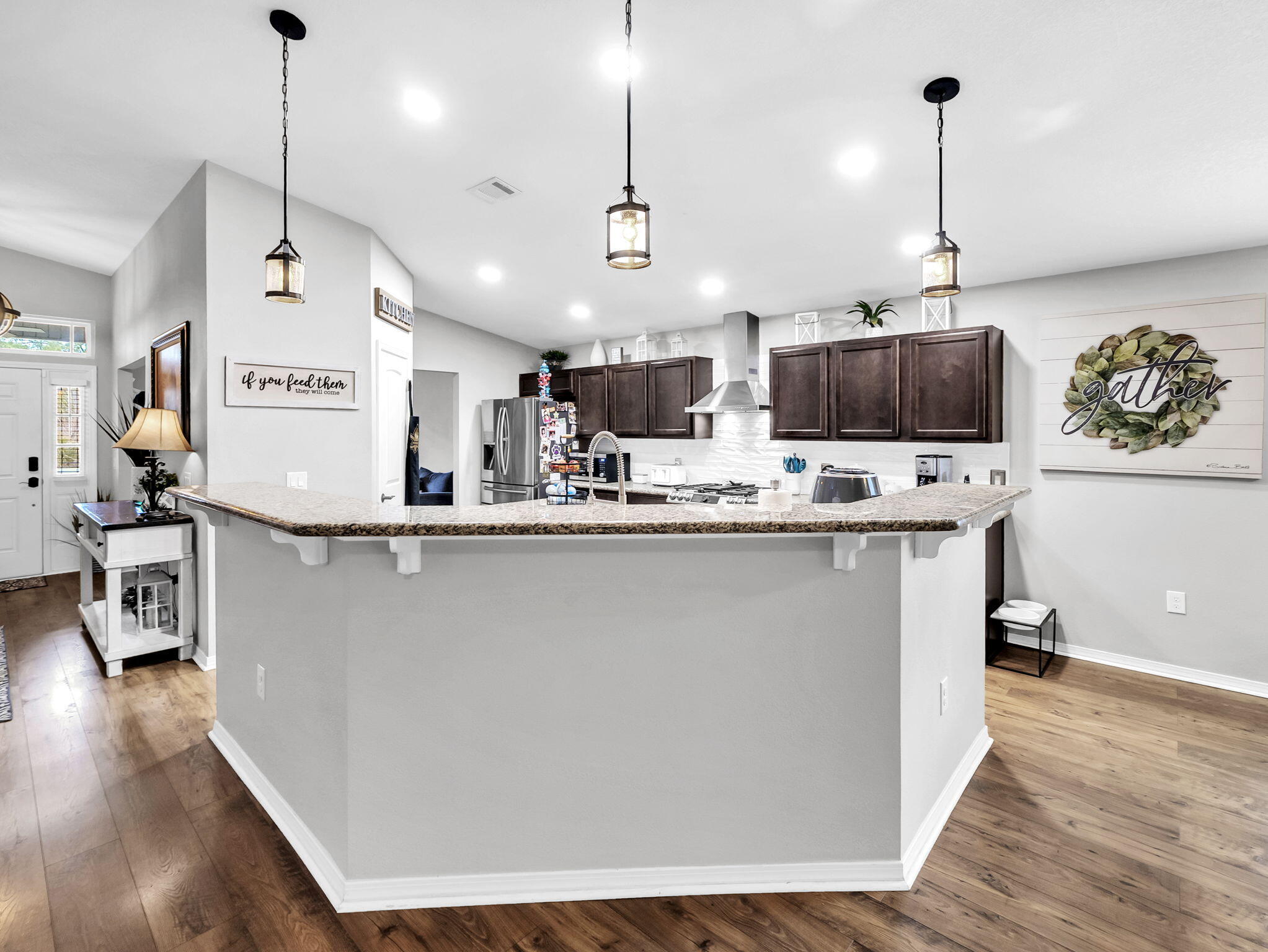 9119 Timber Lane Navarre, FL 32566 - Photo 21 of 53 a large kitchen with stainless steel appliances kitchen island granite countertop a sink a stove and a wooden floor
