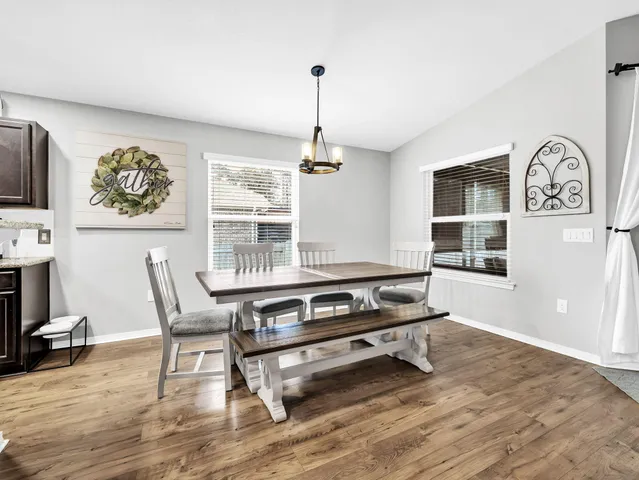 a living room with dining table and a chandelier