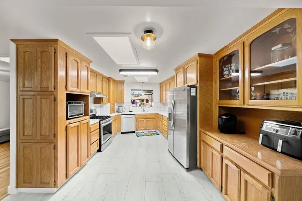 a kitchen with stainless steel appliances a refrigerator and a stove top oven