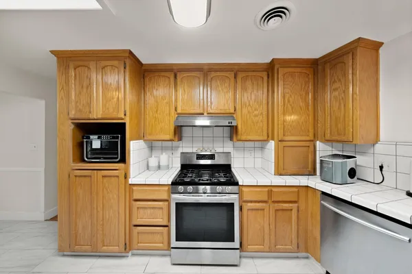 a kitchen with granite countertop a stove and cabinets