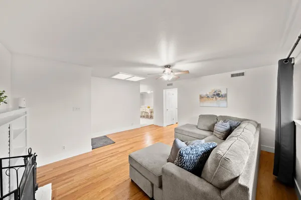 a living room with furniture and a ceiling fan