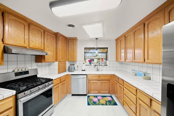 a kitchen with a sink a stove and cabinets