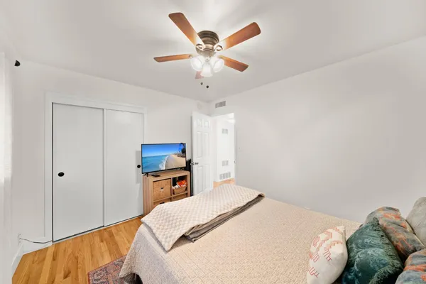 a bedroom with a bed and a ceiling fan